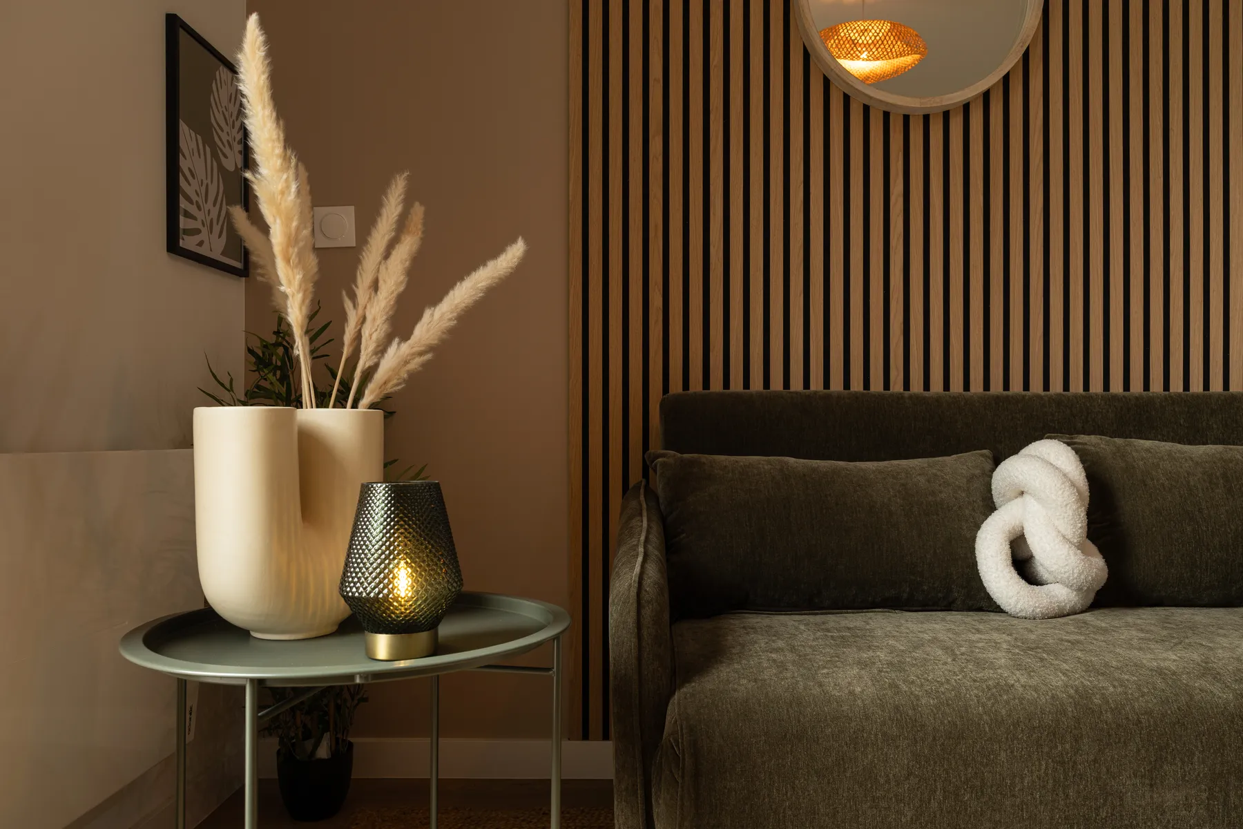 Salon d'un appartement Airbnb décoré par LD Interior Design au Mans, tasseaux bois et canapé vert